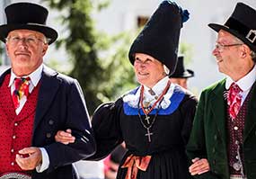 Persone con costumi tipici in Val Gardena